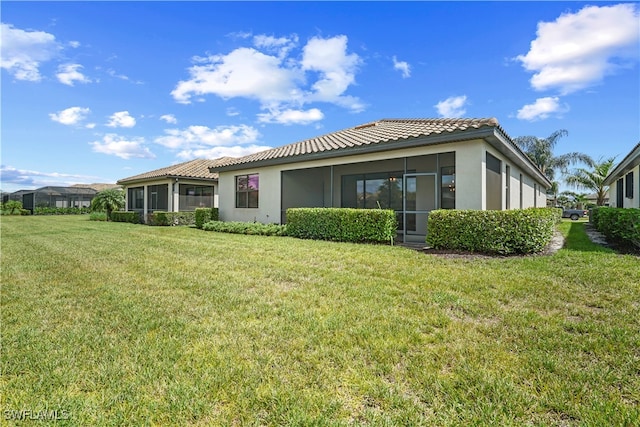 back of house featuring a sunroom and a yard