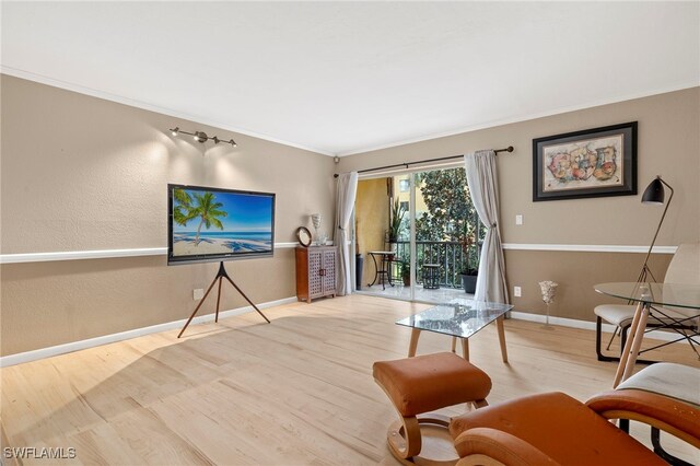 living room with light hardwood / wood-style floors and crown molding