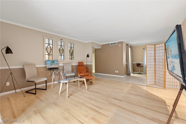 living area with ornamental molding, wood finished floors, and visible vents