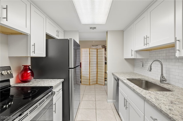 kitchen featuring light tile patterned floors, stainless steel appliances, a sink, visible vents, and white cabinetry