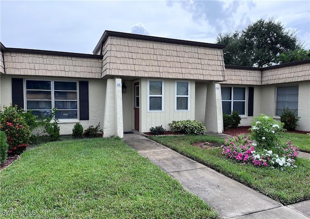 55 Laconia Ct, Fort Myers, FL 33919 - view of front of home featuring stucco siding, mansard roof, and a front yard