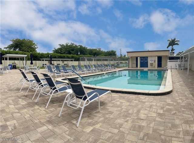 community pool featuring a patio and fence