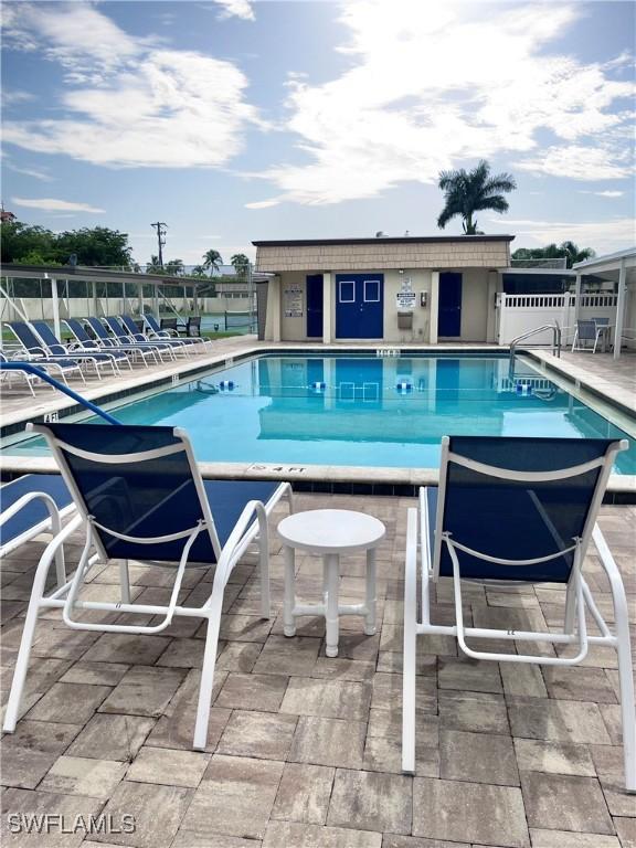 community pool with a patio area and fence