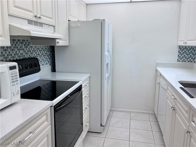 kitchen with light tile patterned floors, backsplash, white appliances, and white cabinets