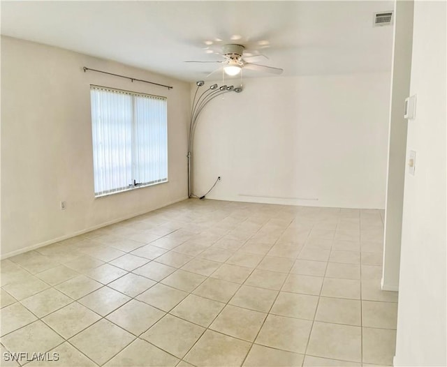 empty room featuring light tile patterned floors, ceiling fan, and visible vents