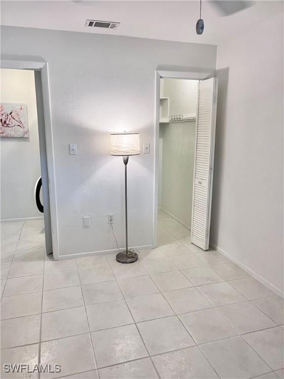 interior space with a closet, visible vents, and light tile patterned flooring