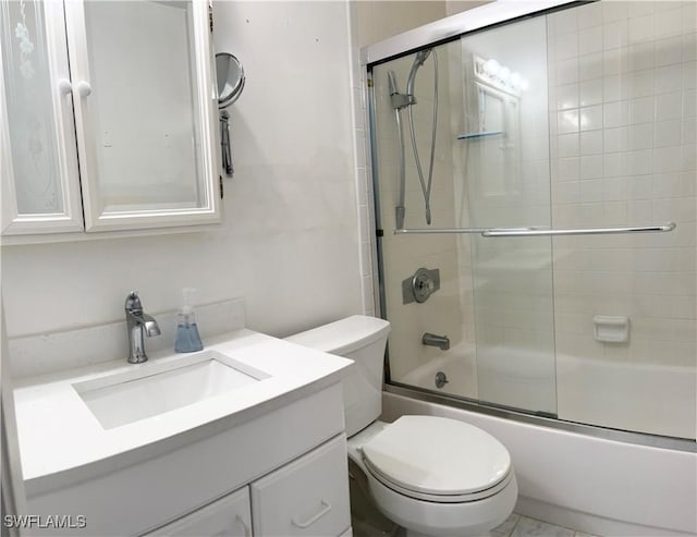 bathroom featuring combined bath / shower with glass door, vanity, and toilet