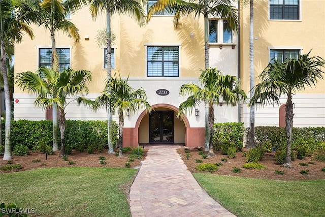 property entrance with a yard and french doors