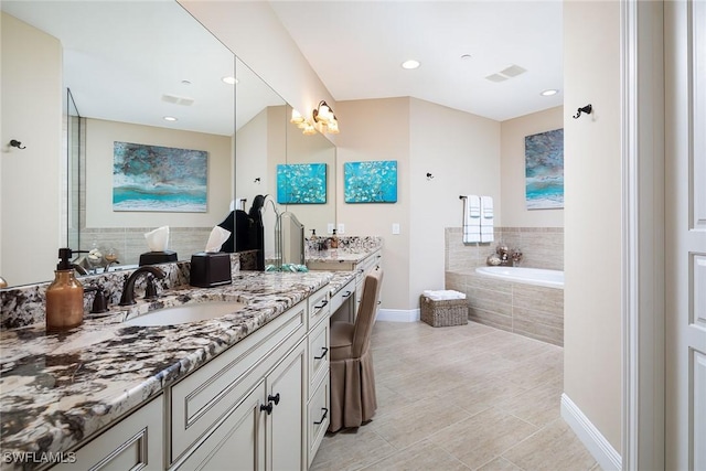 bathroom featuring vanity, tiled bath, and tile patterned floors