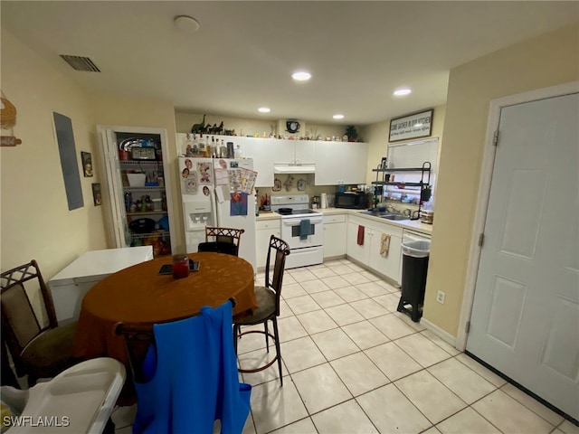 kitchen with white cabinets, sink, light tile patterned floors, and white appliances