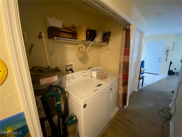 laundry room featuring hardwood / wood-style flooring, electric water heater, and washing machine and clothes dryer