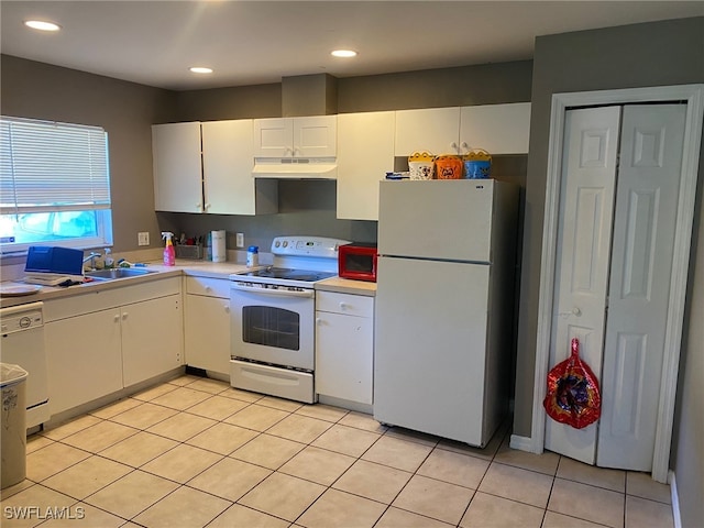 kitchen featuring white cabinets, sink, light tile patterned floors, and white appliances