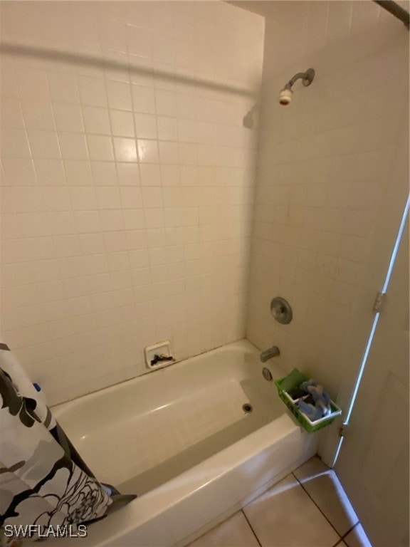 bathroom with shower / bath combo with shower curtain and tile patterned floors