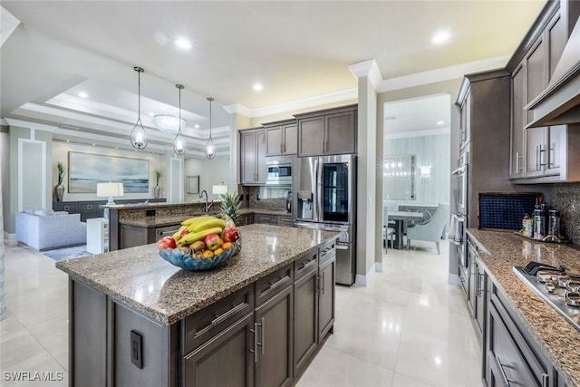 kitchen featuring stone counters, stainless steel appliances, pendant lighting, a kitchen island with sink, and custom range hood