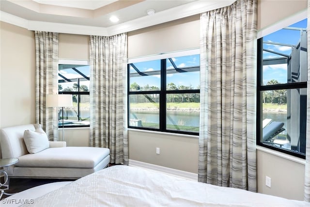 bedroom featuring a water view and crown molding