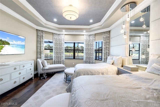 bedroom featuring a tray ceiling, crown molding, and dark wood-type flooring