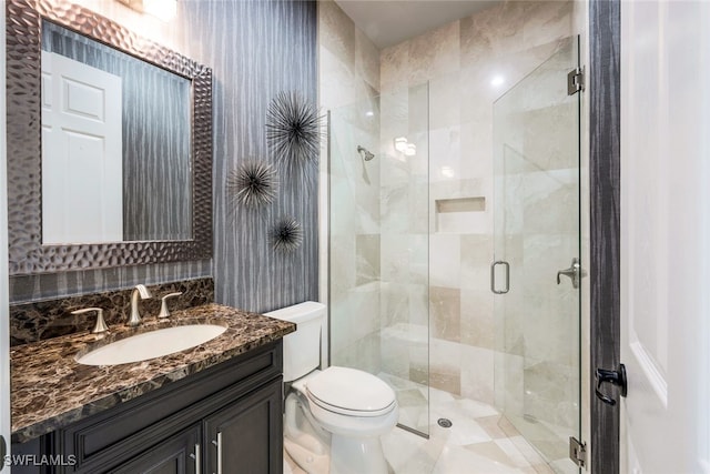 bathroom featuring vanity, toilet, and an enclosed shower