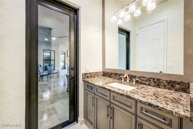 bathroom featuring ceiling fan, a textured ceiling, and vanity