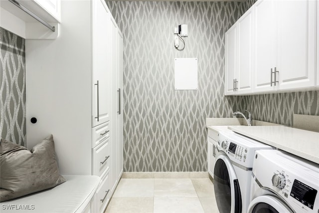 laundry room featuring cabinets, light tile patterned floors, washer and dryer, and sink