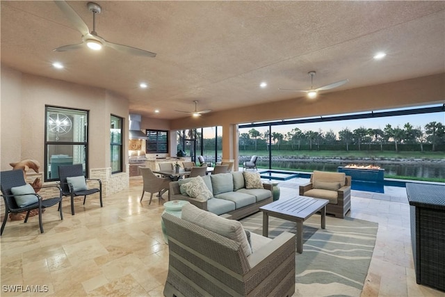 living room featuring a healthy amount of sunlight, a water view, and a textured ceiling