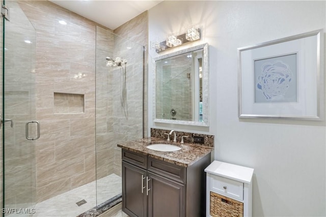 bathroom featuring vanity and a shower with shower door