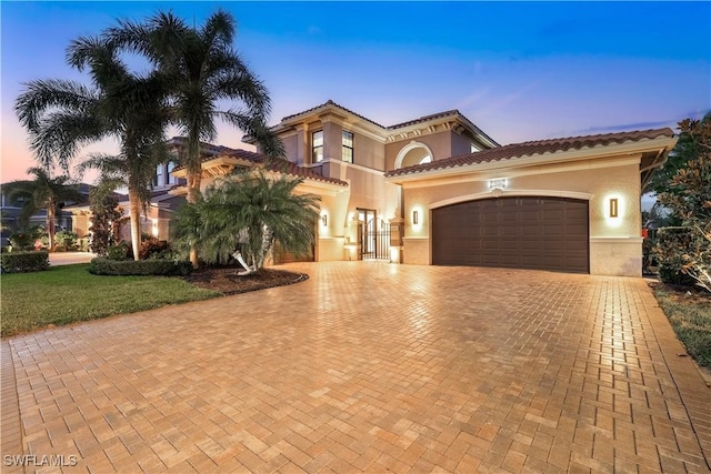 mediterranean / spanish-style home featuring a garage and a lawn