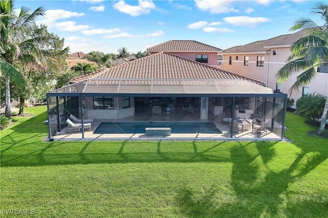 rear view of property featuring a lawn, a patio area, a swimming pool with hot tub, and a lanai