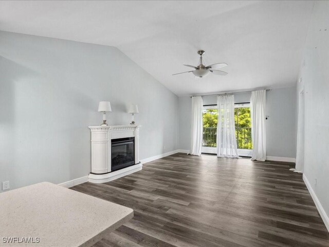 unfurnished living room with ceiling fan, vaulted ceiling, and dark wood-type flooring