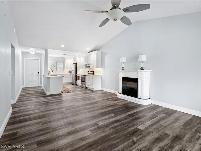 unfurnished living room featuring dark hardwood / wood-style flooring, vaulted ceiling, sink, and ceiling fan