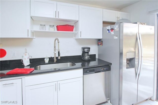 kitchen with stainless steel appliances, a sink, open shelves, and white cabinetry