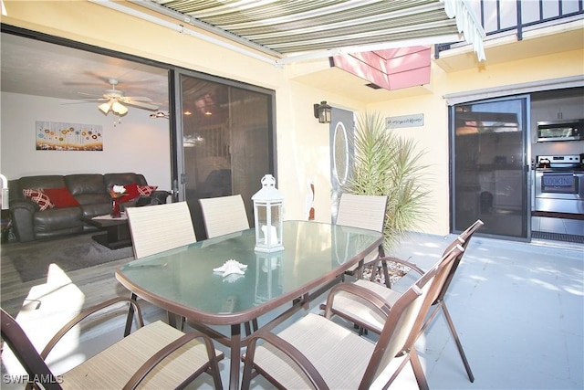 view of patio with outdoor dining space and a ceiling fan