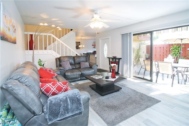 living room with wood finished floors, stairs, and ceiling fan