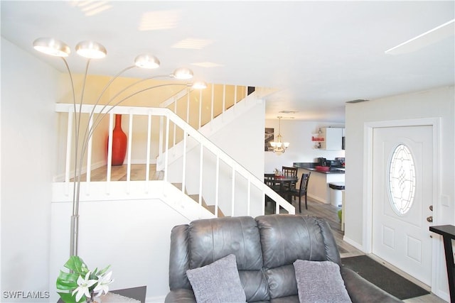 entrance foyer with stairs, a chandelier, and baseboards