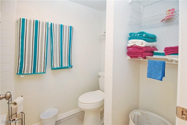 bathroom with toilet and tile patterned floors