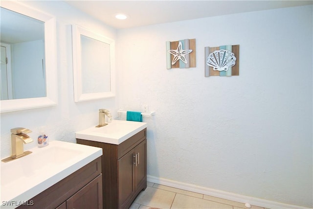 bathroom featuring two vanities, tile patterned floors, and baseboards