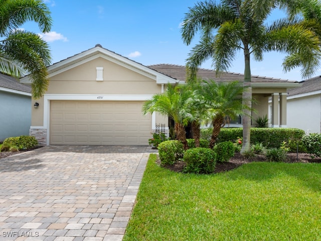 single story home featuring a garage and a front yard