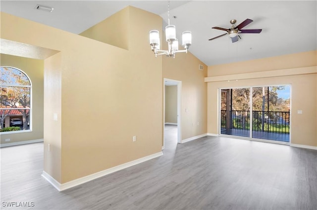 spare room featuring high vaulted ceiling, wood finished floors, and baseboards