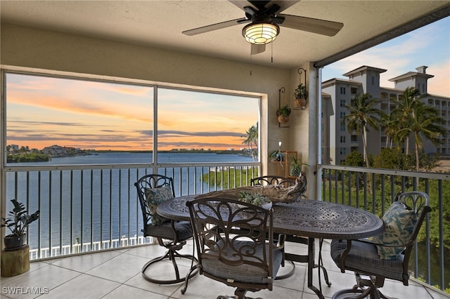 sunroom / solarium featuring a water view and ceiling fan