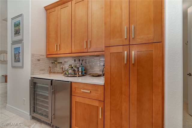 bar with tasteful backsplash, beverage cooler, baseboards, and a bar