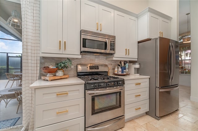 kitchen featuring light countertops, appliances with stainless steel finishes, white cabinets, and decorative backsplash