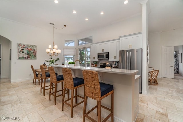 1435 SW 53rd Ln, Cape Coral, FL 33914 - kitchen featuring stone tile floors, a kitchen breakfast bar, appliances with stainless steel finishes, and light countertops