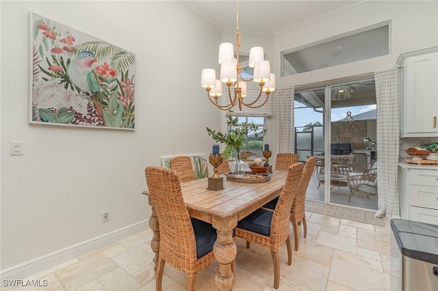 dining area featuring an inviting chandelier, stone tile floors, baseboards, and crown molding