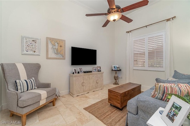 living area with baseboards and a ceiling fan