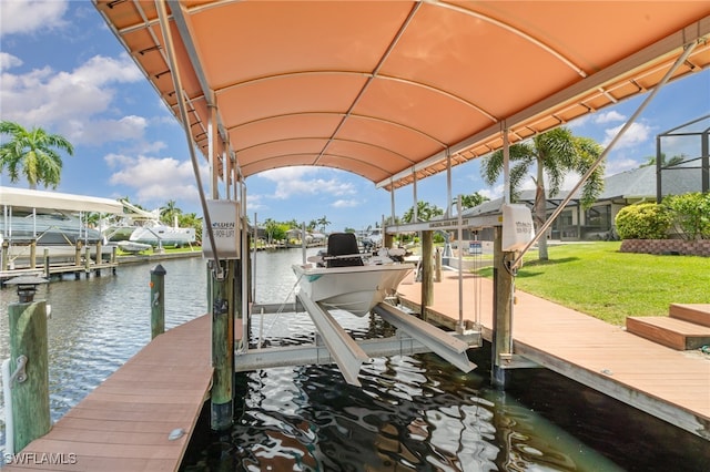 dock area with a water view, boat lift, and a lawn