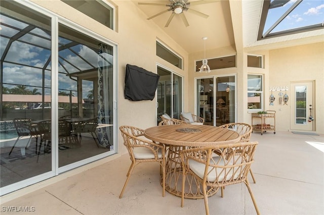 view of patio / terrace with glass enclosure, ceiling fan, and outdoor dining area