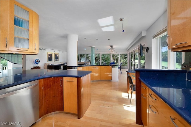 107 Clubhouse Dr Unit 258, Naples, FL 34105 - kitchen featuring dark countertops, glass insert cabinets, light wood-type flooring, dishwasher, and a peninsula