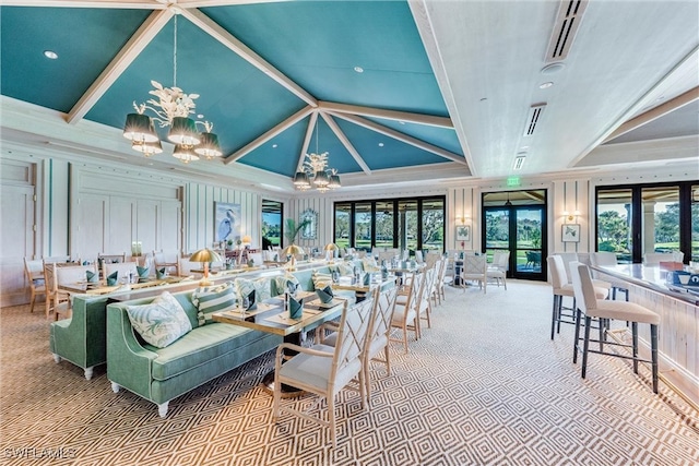 living room featuring a raised ceiling, an inviting chandelier, and french doors