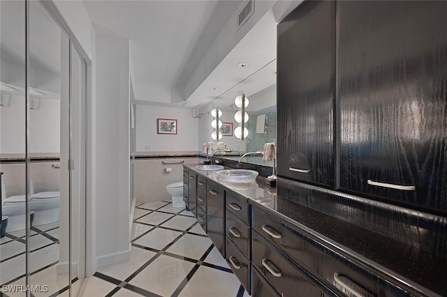 107 Clubhouse Dr Unit 258, Naples, FL 34105 - bathroom featuring toilet, a wainscoted wall, visible vents, tile walls, and double vanity