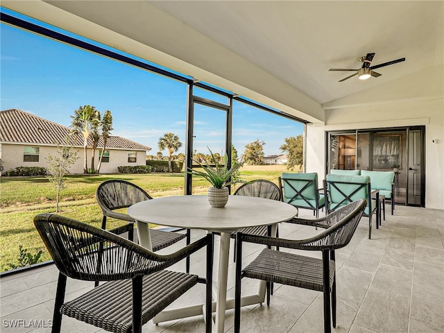 sunroom featuring vaulted ceiling and ceiling fan