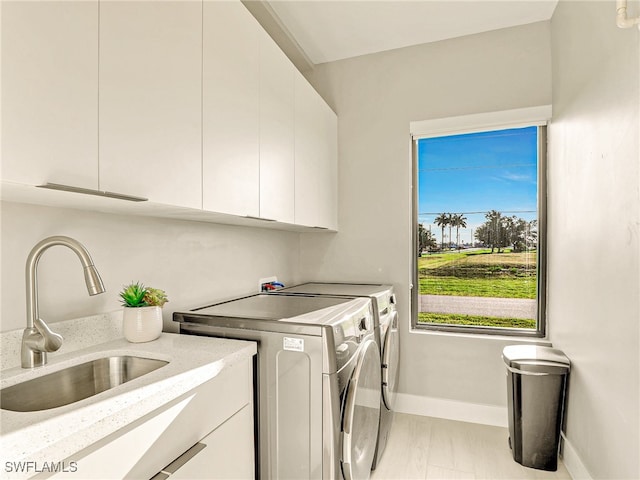 washroom featuring separate washer and dryer, sink, and cabinets